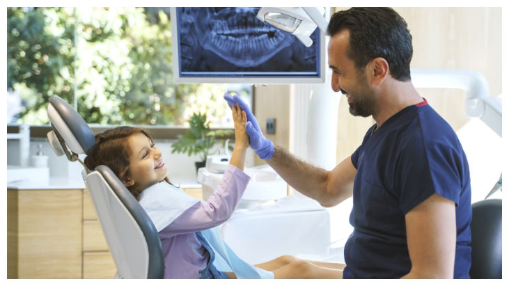 young-girl-in-dental-office-giving-dentist-a-highfive