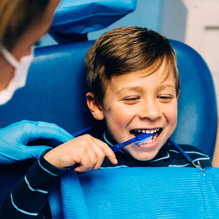 Kid getting teeth cleaning and learning how to brush teeth