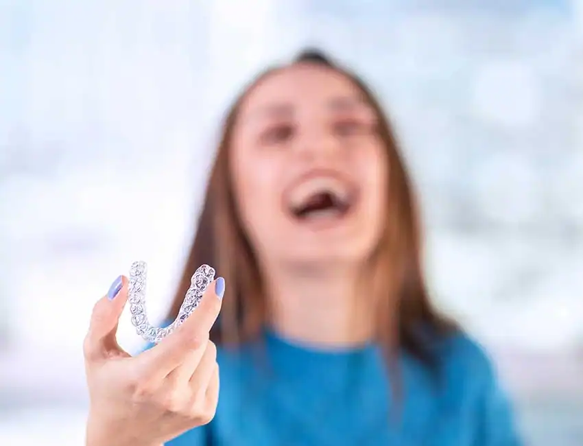 Patient holding her mouthguard in Carlsbad