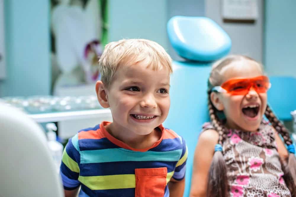 Two children smiling during a dental visit